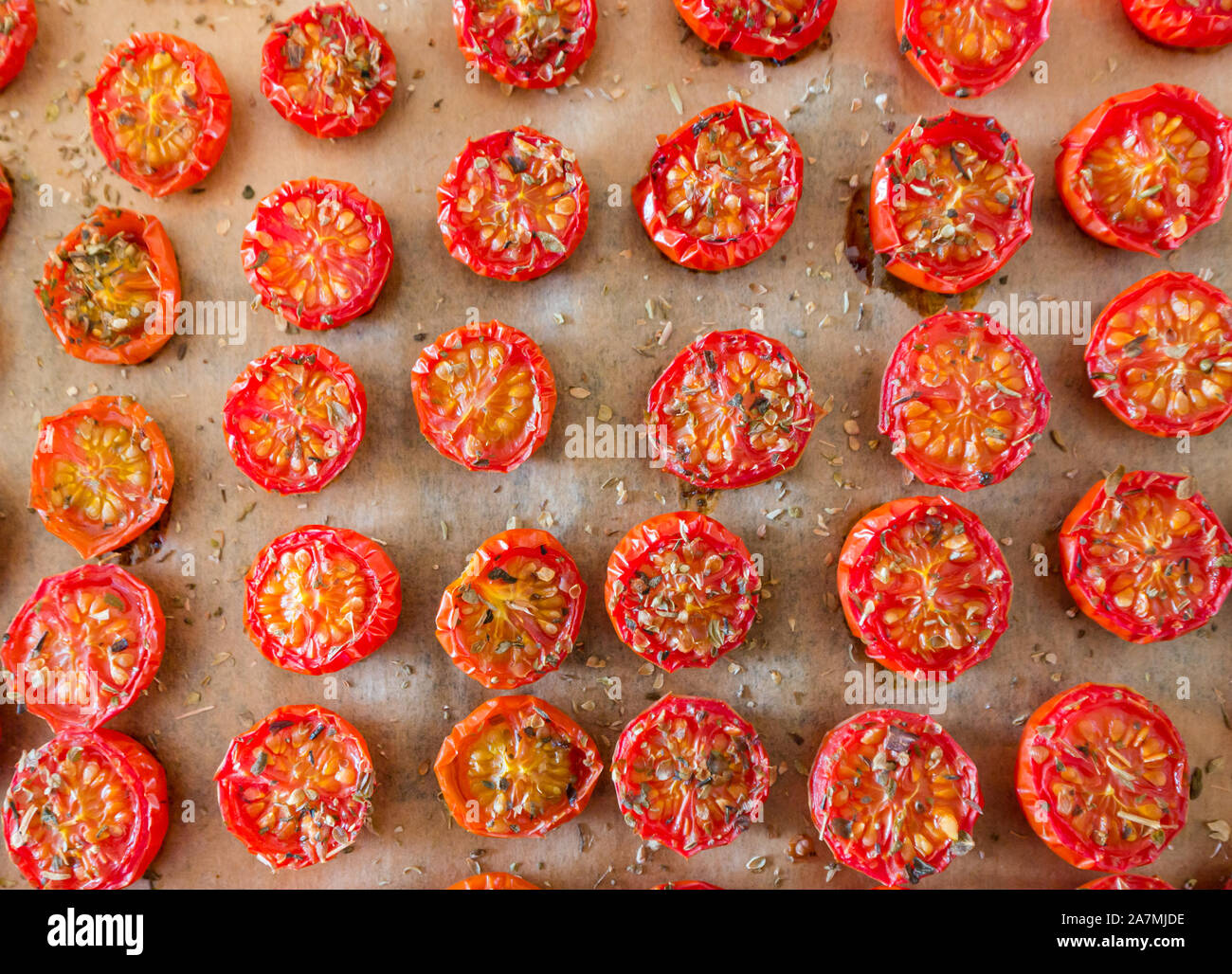 Backblech mit Reihen von gewürzter gebackener oder gerösteter Kirsche Tomaten Stockfoto