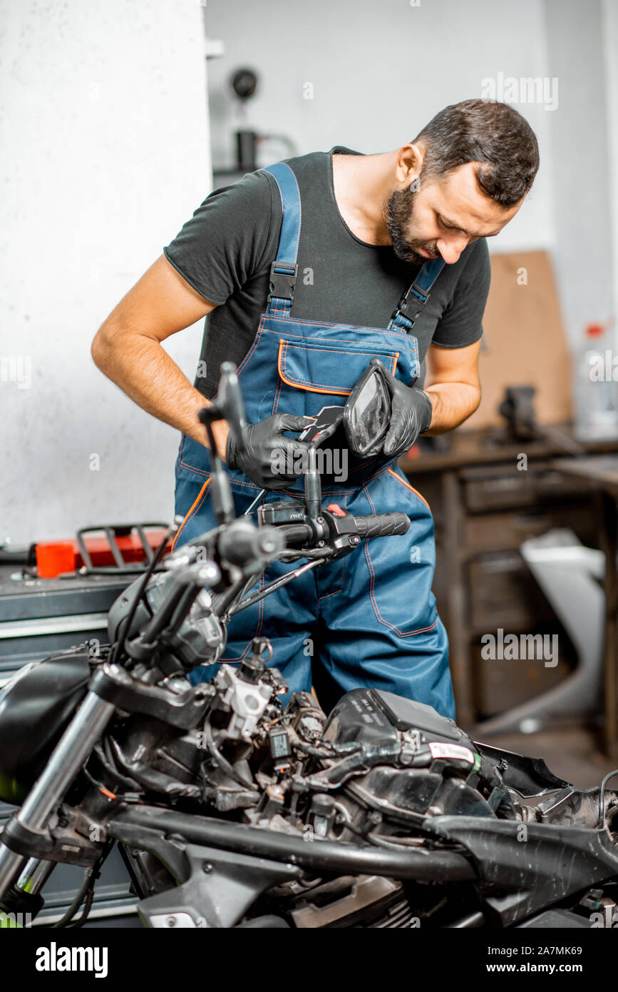 Mechaniker in Latzhosen Motorrad reparieren, Messen spiegel halter