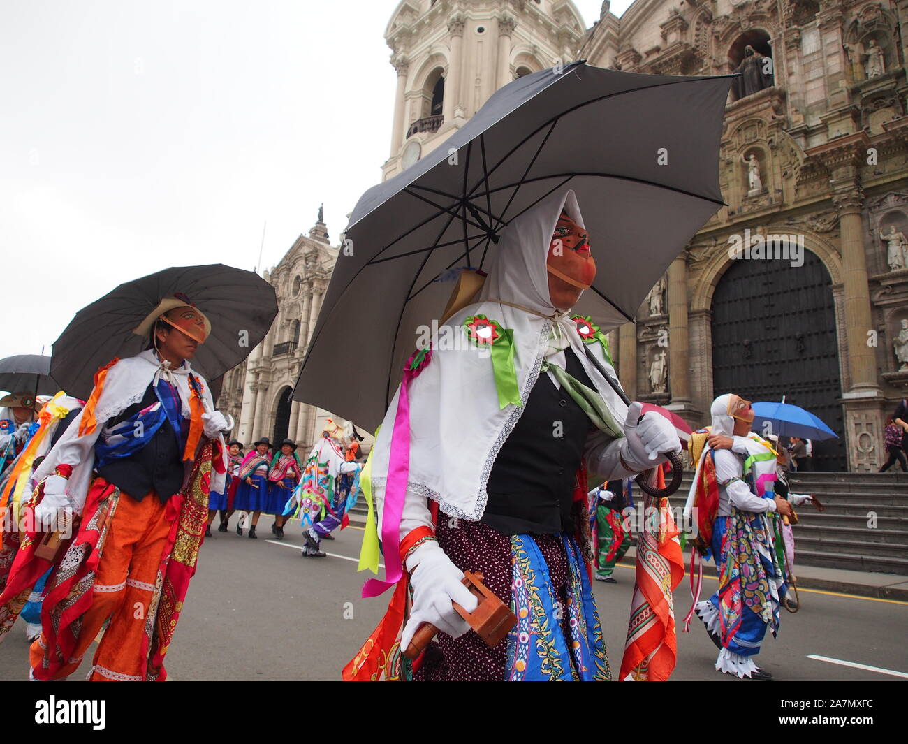 Eine maskierte Volkstänzer tragen typische Kostüm- und Regenschirm in der Prozession und Parade teilnehmenden für Jude der Apostel (Hl. Judas Thaddäus) in der Innenstadt von Lima. Stockfoto