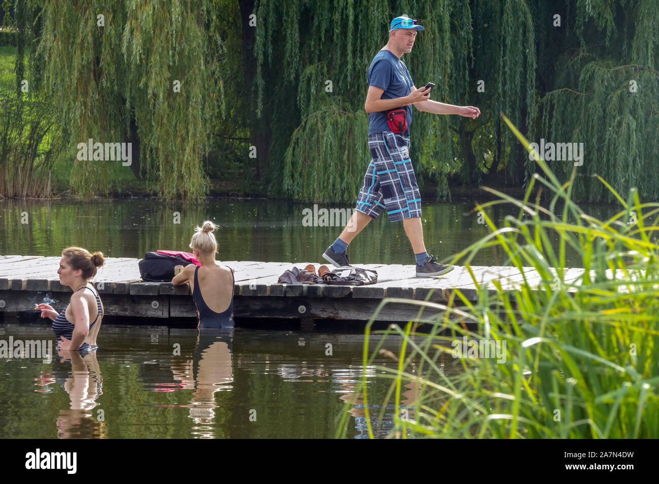 Prager Park Sommer zwei Frauen, die baden, ein Mann, der auf einer Holzbrücke geht, im Stadtpark Stromovka Prag Tschechische Republik Sommer Stromovka Park Stockfoto