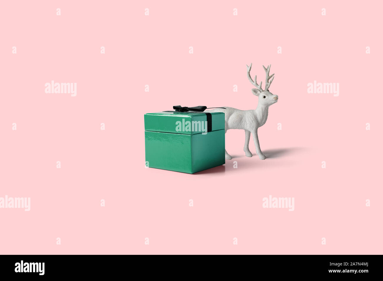 Weihnachten Geschenk "Jobticket", mit Schleife dekoriert, Pine Cone Ornament und weiße Rentier auf rosa Hintergrund. Weihnachten, Winter, neues Jahr minimalen Begriff Stockfoto