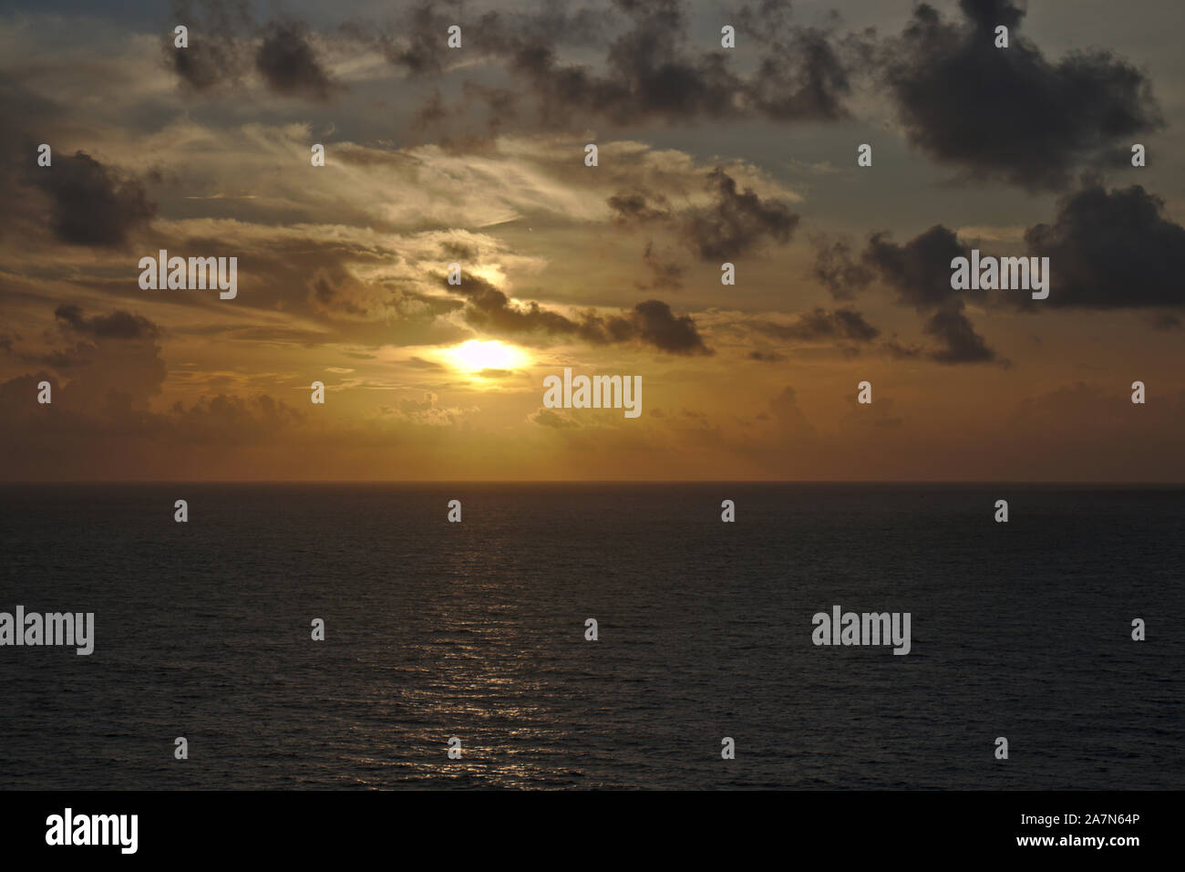 Gelb orange Sonnenuntergang über dem Ozean und dramatische Wolken. Stockfoto