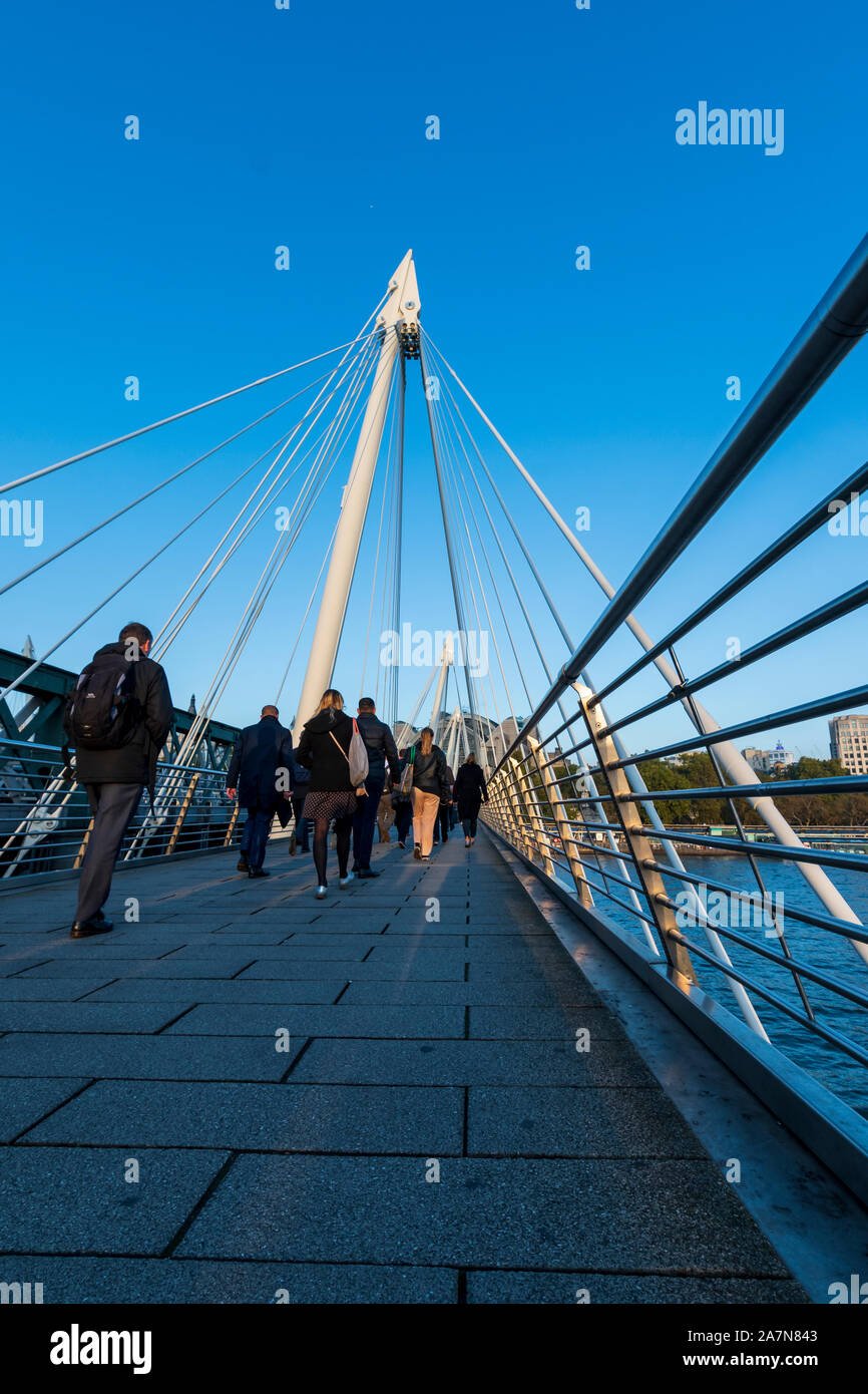 Menschen zu Fuß in Richtung Bahnhof Charing Cross über die Golden Jubilee Bridge in London. Stockfoto