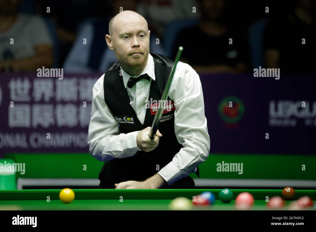 Gary Wilson von England hält einen Schuß zu Mark Selby von England in ihren Viertelfinalegleichen während der 2019 World Snooker Internationale Meisterschaft Stockfoto