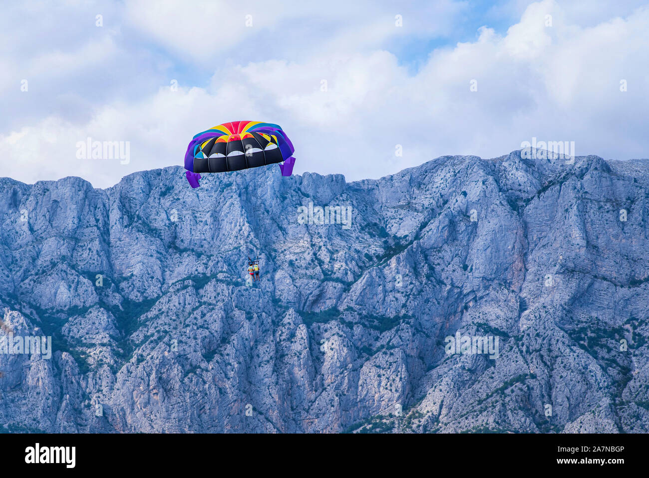Kroatien, fliegende farbige Fallschirm auf dem Hintergrund der Dolomiten. Bunte paragliding Bildung. Stockfoto