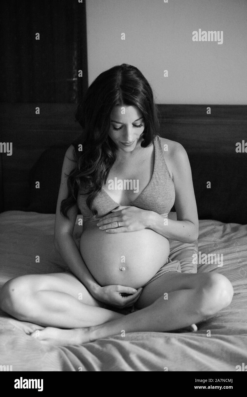 Schwangere Frau im Bett Schwarz und Weiß Stockfoto