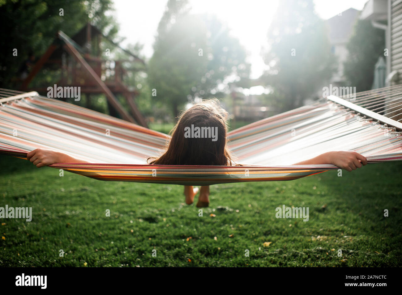 Tween girl eine Pause beim Schwingen in der Hängematte im Hinterhof Stockfoto