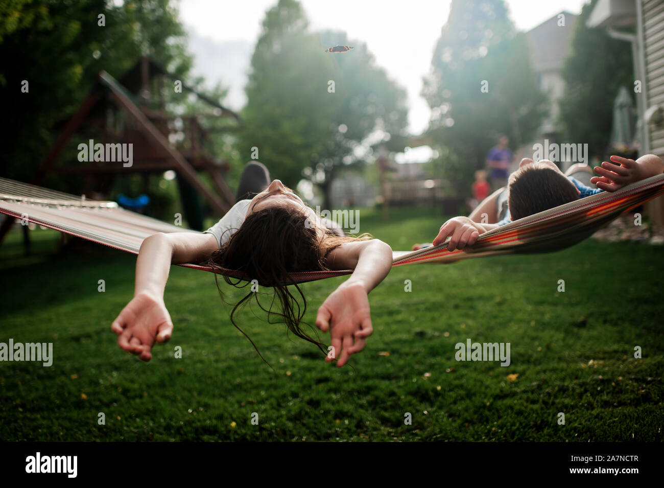 Bruder und Schwester zusammen in der Hängematte relaxen im Hinterhof Stockfoto