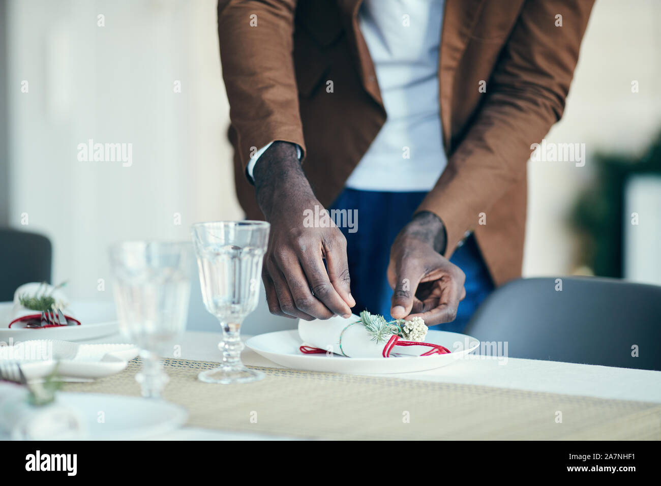 Nahaufnahme der afroamerikanischen Mann Vorbereitung Tabelle Einstellung beim Dekorieren Speisesaal für das Weihnachtsfest zu Hause, Kopie Raum Stockfoto