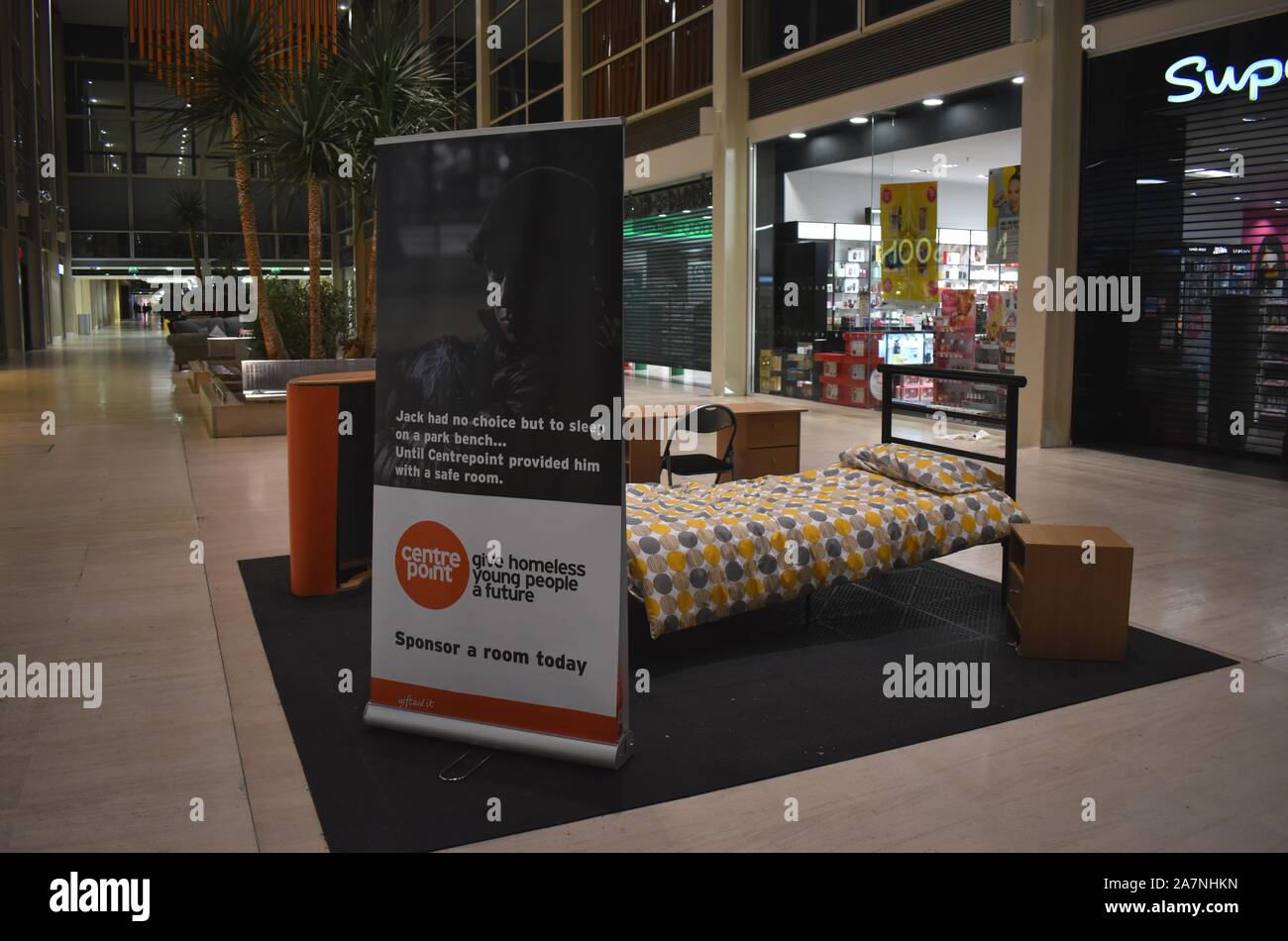 Ein Mock up aus einem Schlafzimmer im Einkaufszentrum in Milton Keynes. Eine Anzeige für centrepoint Liebe, während die Obdachlose schlafen draußen auf der Straße. Stockfoto