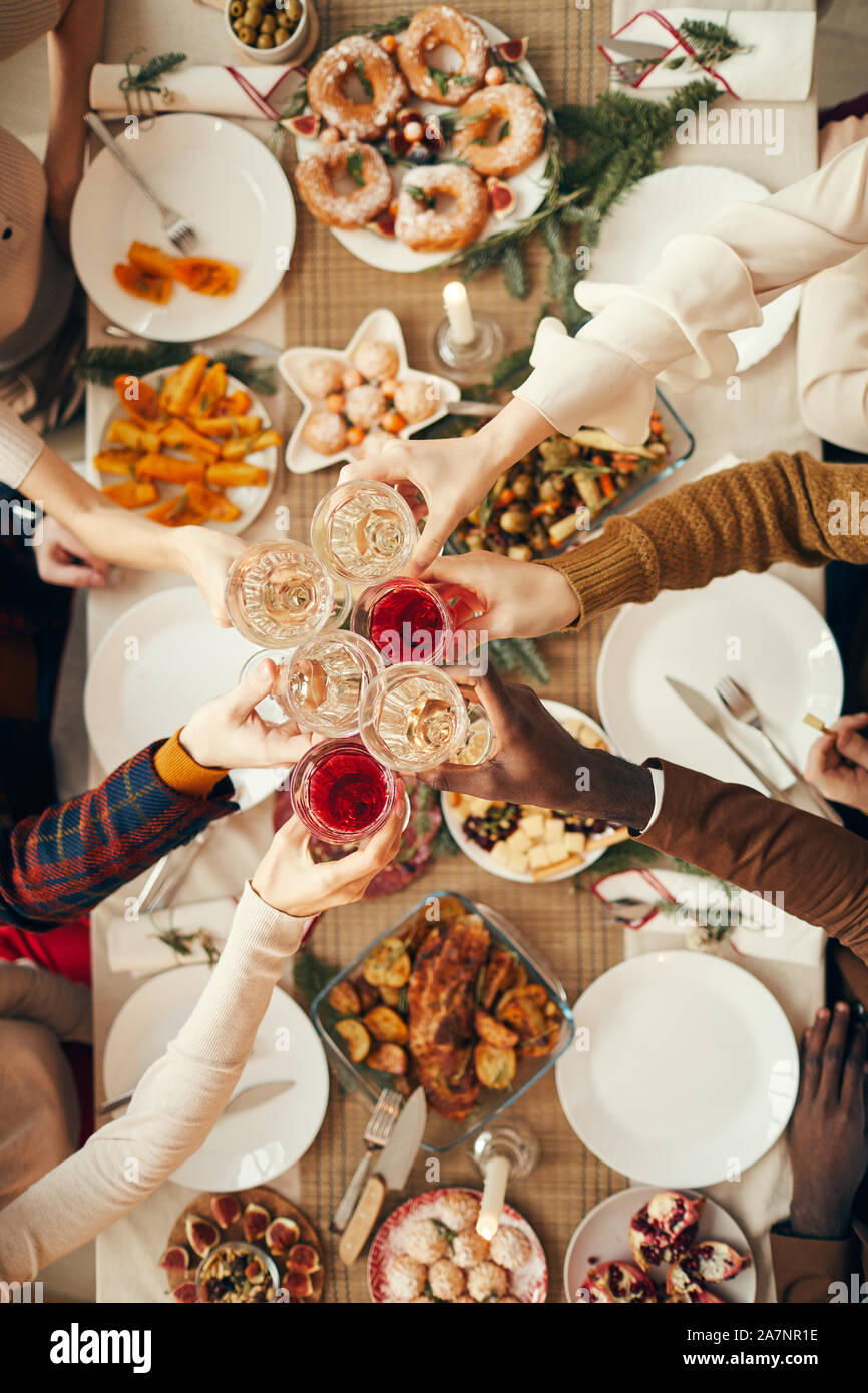 Vor Hintergrund der Ansicht der Menschen erhöhen Gläser über festliche Abendessen, während wir Weihnachten feiern mit Freunden und Familie, kopieren Raum Stockfoto
