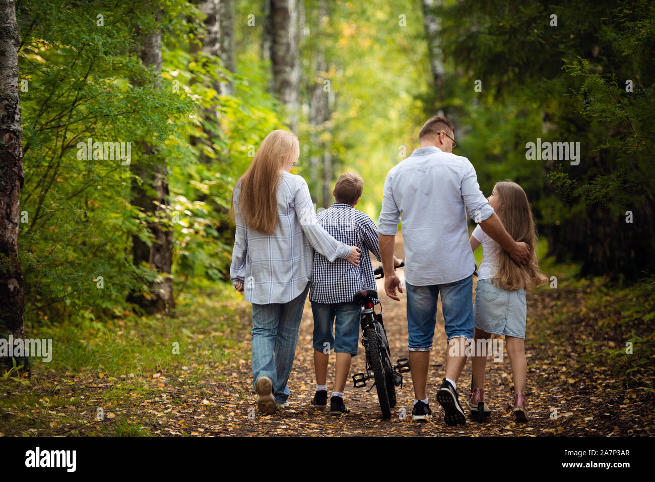Rückansicht - eine Familie mit zwei Kindern Spaziergänge im Park. Stockfoto