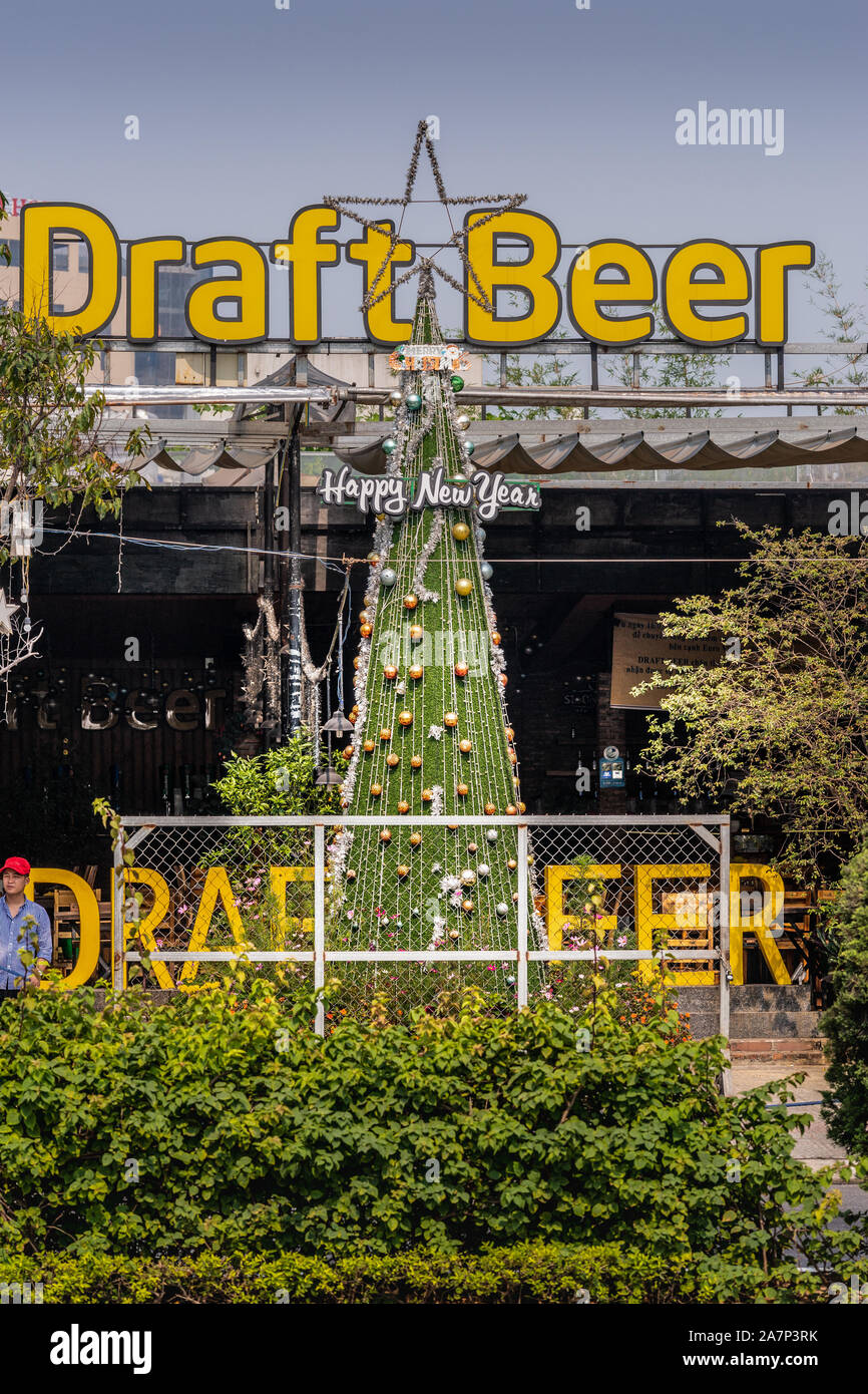 Da Nang, Vietnam - März 10, 2019: riesige gelbe Zeichen für Bier in der Bar in der Nähe von Memorial Park unter blauem Himmel mit grünem Laub. Zweites Zeichen r Stockfoto