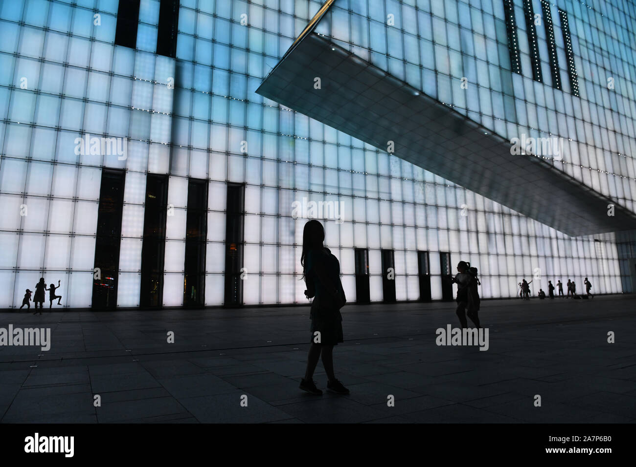 Besucher posieren für Fotos vor einem farbigen Hintergrund Silhouetten an das Chongqing Grand Theatre in Chongqing, China, 2. August 2019 zu erstellen. Stockfoto