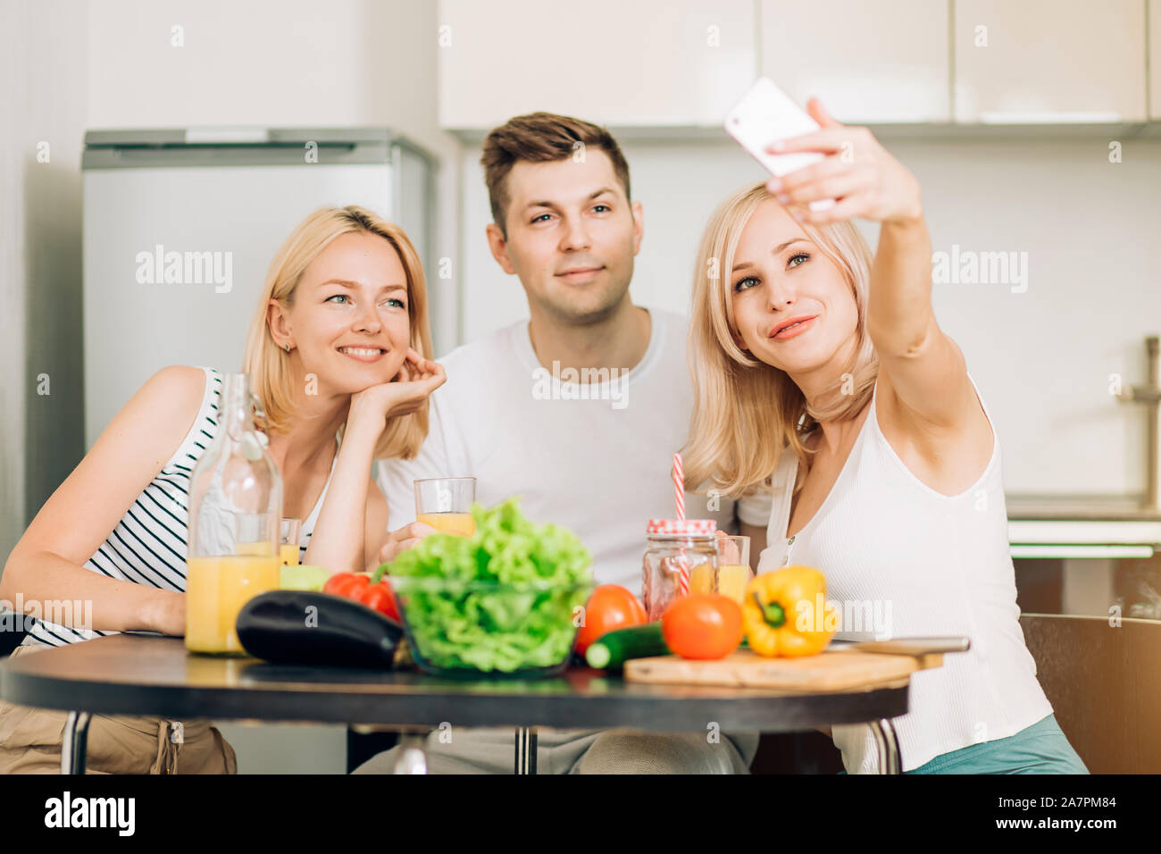 Gruppe von Freunden Spaß in der Küche und lächelte, wobei selfie, Zubereitung von Salat. Selektive konzentrieren. Social Media, Technik, Kochen, Studenten Stockfoto