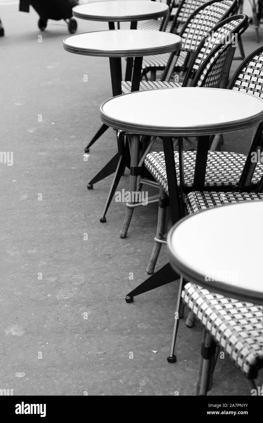 Paris, Frankreich. Café Terrace Tisch mit Wickerstühlen. Klassisches Französisches Café Mit Blick Auf Die Uhr. Stockfoto