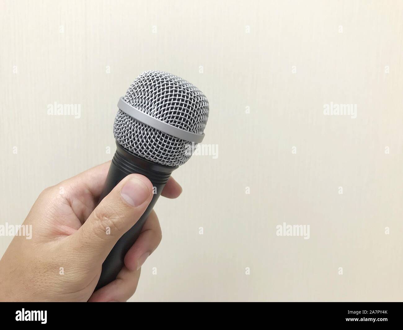 Die menschliche Hand mit einem Mikrofon für das Sprechen oder Singen. Stockfoto