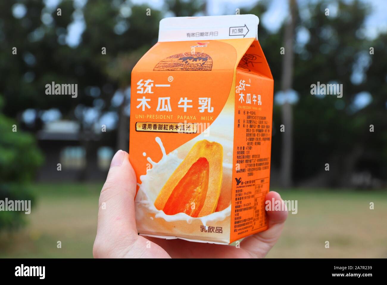 KENTING, TAIWAN - 28. NOVEMBER 2018: Kunde hand Uni-President Papaya Milch trinken in Taiwan. Uni-President ist ein internationaler Lebensmittel conglo Stockfoto