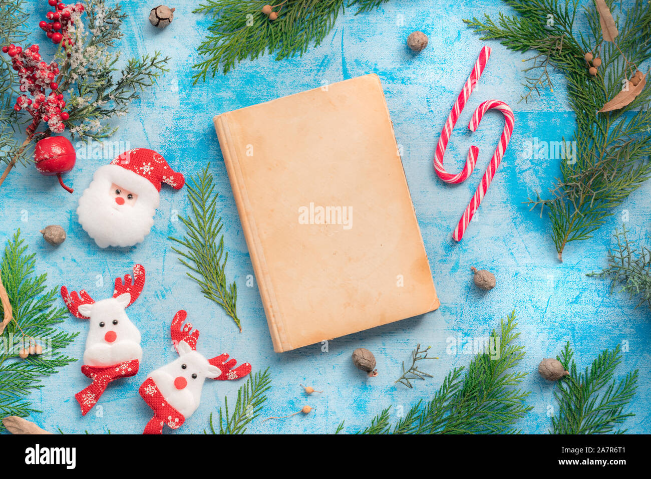 Weihnachtsdekoration und vintage Märchenbuch mock up auf dem Tisch, flach Top View Stockfoto