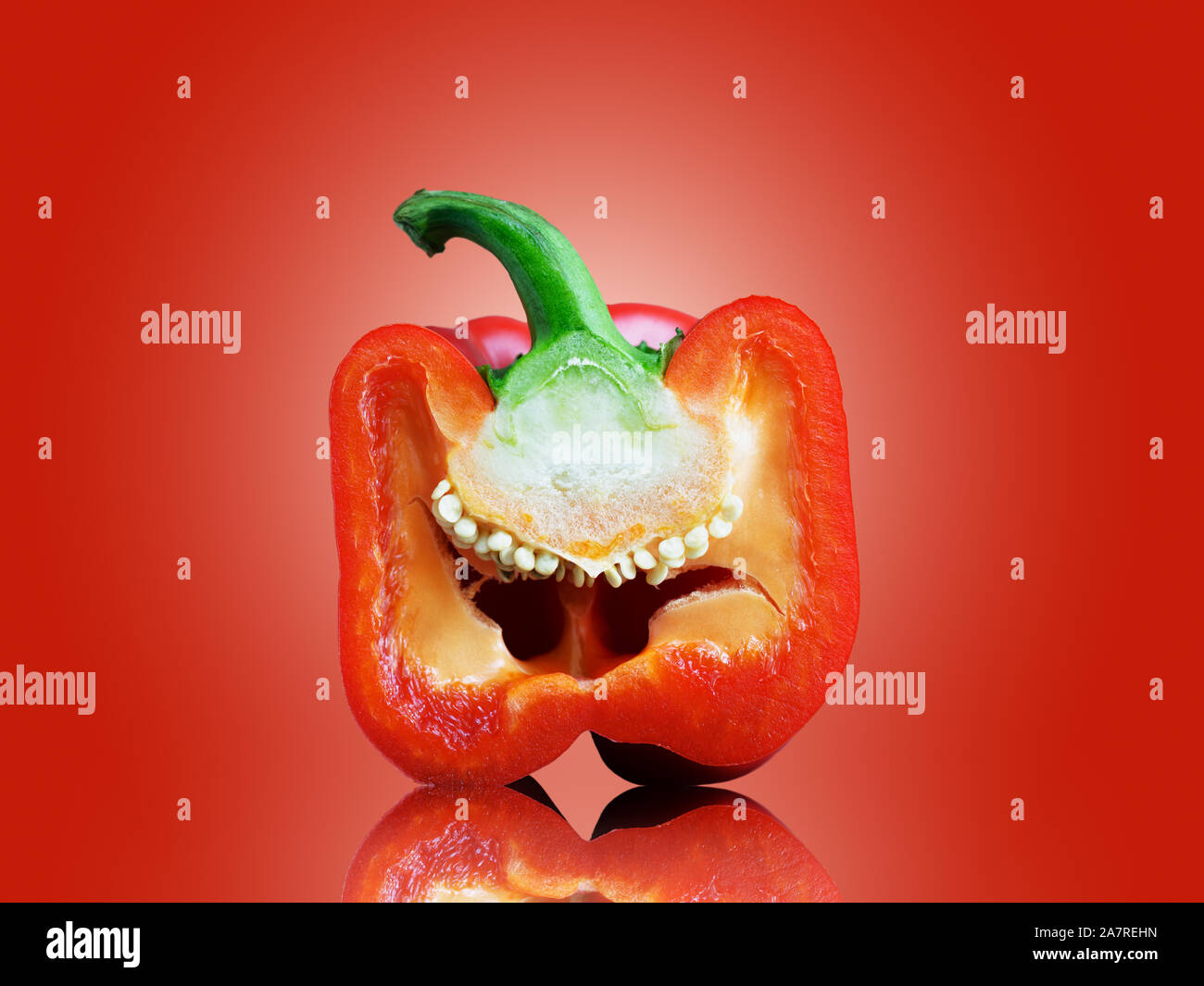 Red Pepper auf rotem Hintergrund mit der Pfeffer in der Hälfte isoliert. Capsicum Stockfoto