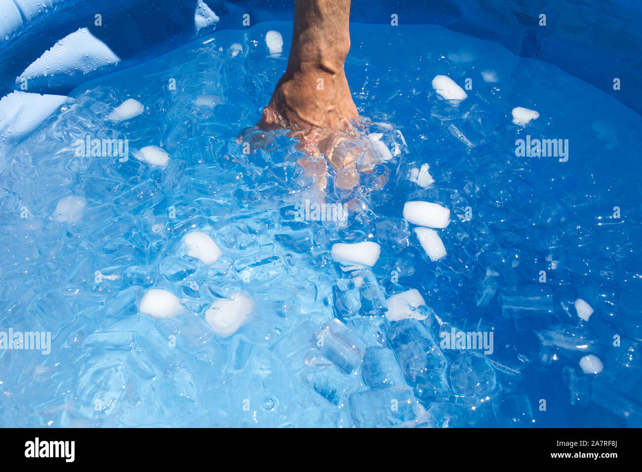 Hand in Eisbad im Schwimmbad. Stockfoto