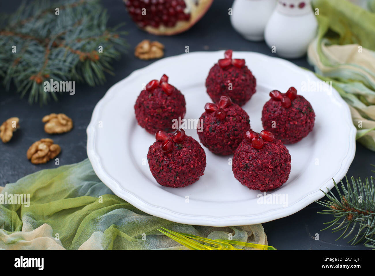 Traditionelle georgische Vorspeise pkhali aus Rüben, Walnüsse und Granatapfel. Auf einer weißen Platte gegen einen dunklen Hintergrund entfernt Stockfoto