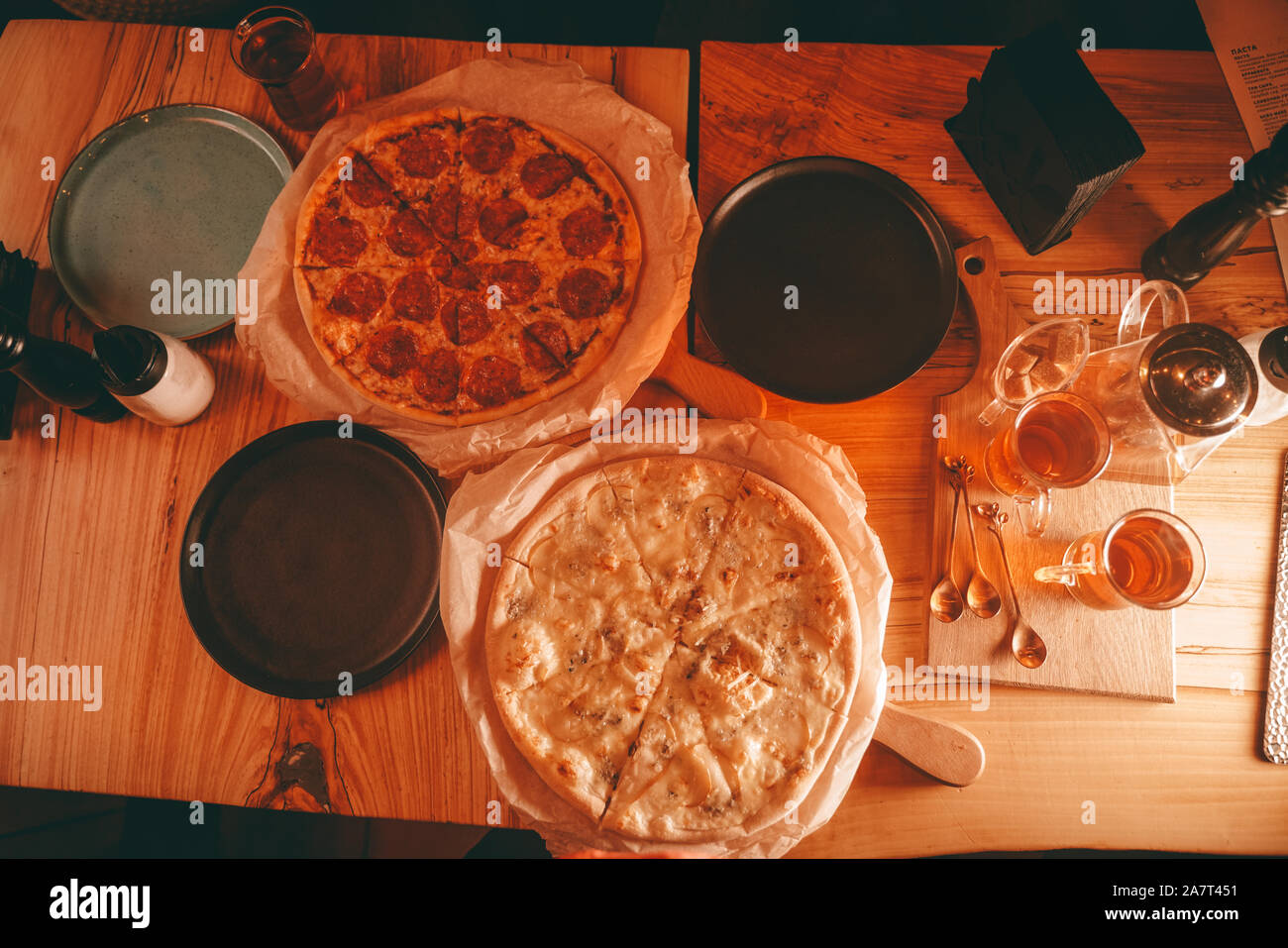 Köstliche frische, hausgemachte Pizza auf dem Tisch. Pizza mit Birne und Grün Blau Käse und die klassische Pepperoni Pizza mit Würstchen, Ansicht von oben Stockfoto
