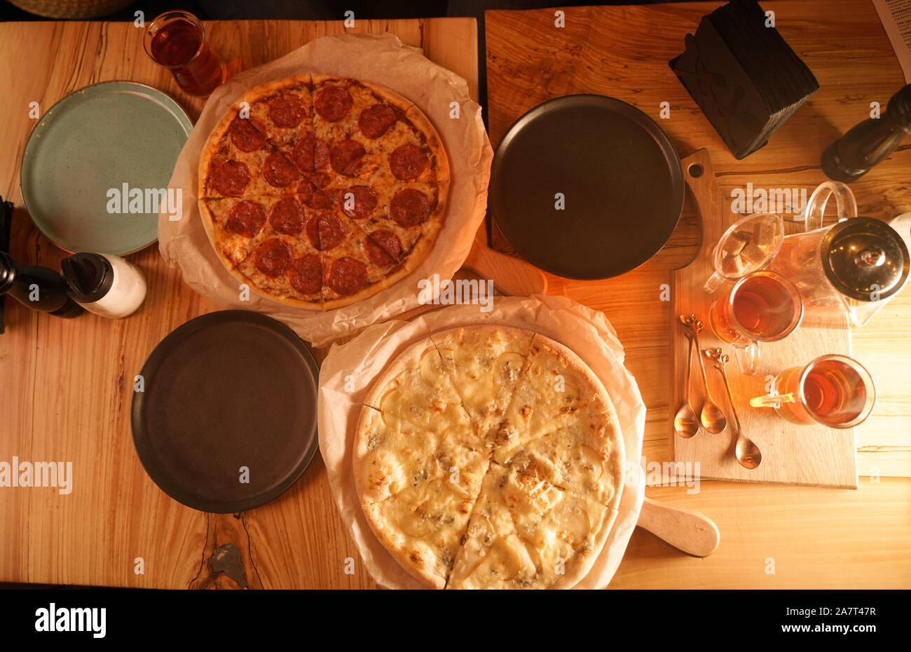 Köstliche frische, hausgemachte Pizza auf dem Tisch. Pizza mit Birne und Grün Blau Käse und die klassische Pepperoni Pizza mit Würstchen, Ansicht von oben Stockfoto