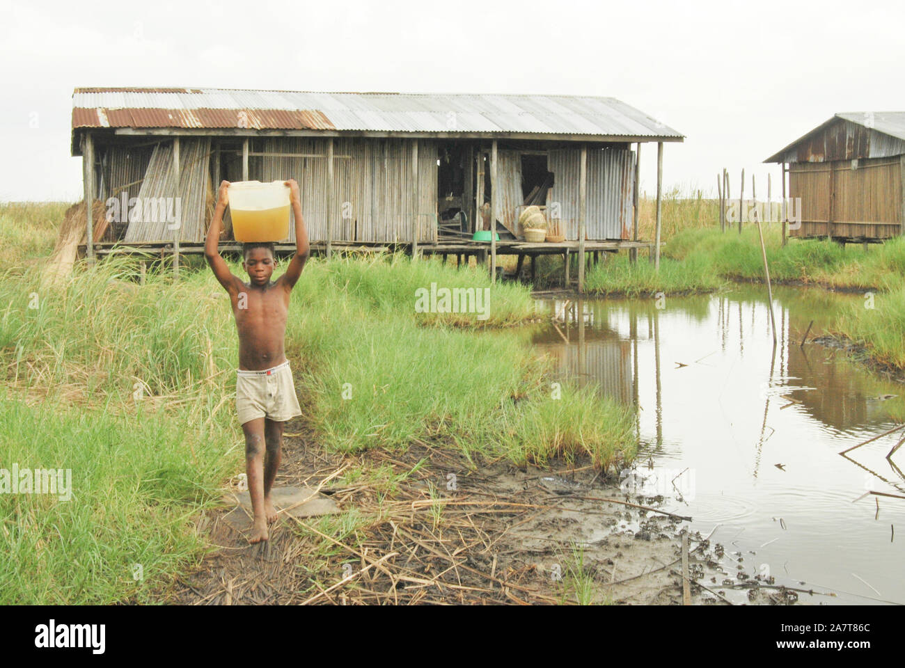 Ein Junge, der in Idi-Ogba, Bundesstaat Ondo, Nigeria, verunreinigtes Wasser zum Trinken holt. Stockfoto