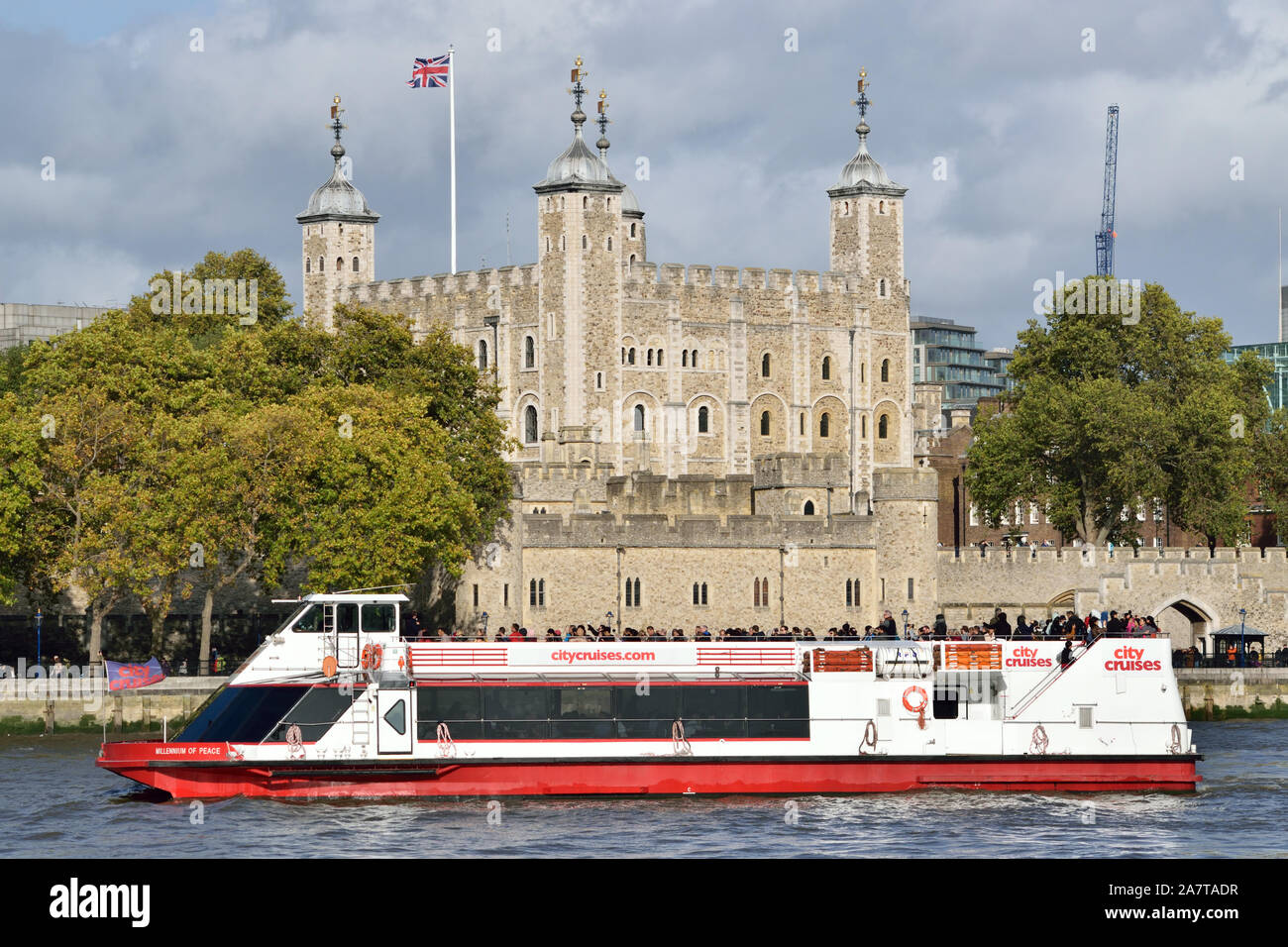 Eines der City Cruises London Sightseeing-Boote auf der Themse vorbei an den Tower of London Stockfoto
