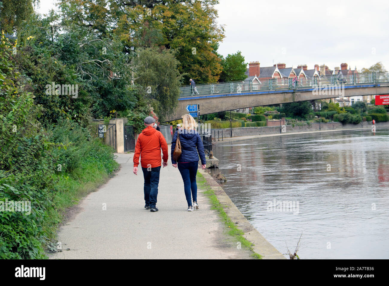 Zurück Blick auf zwei Menschen, Mann, Frau, Wandern entlang der Ufer des Flusses Severn in der Stadt Shrewsbury England UK KATHY DEWITT Stockfoto