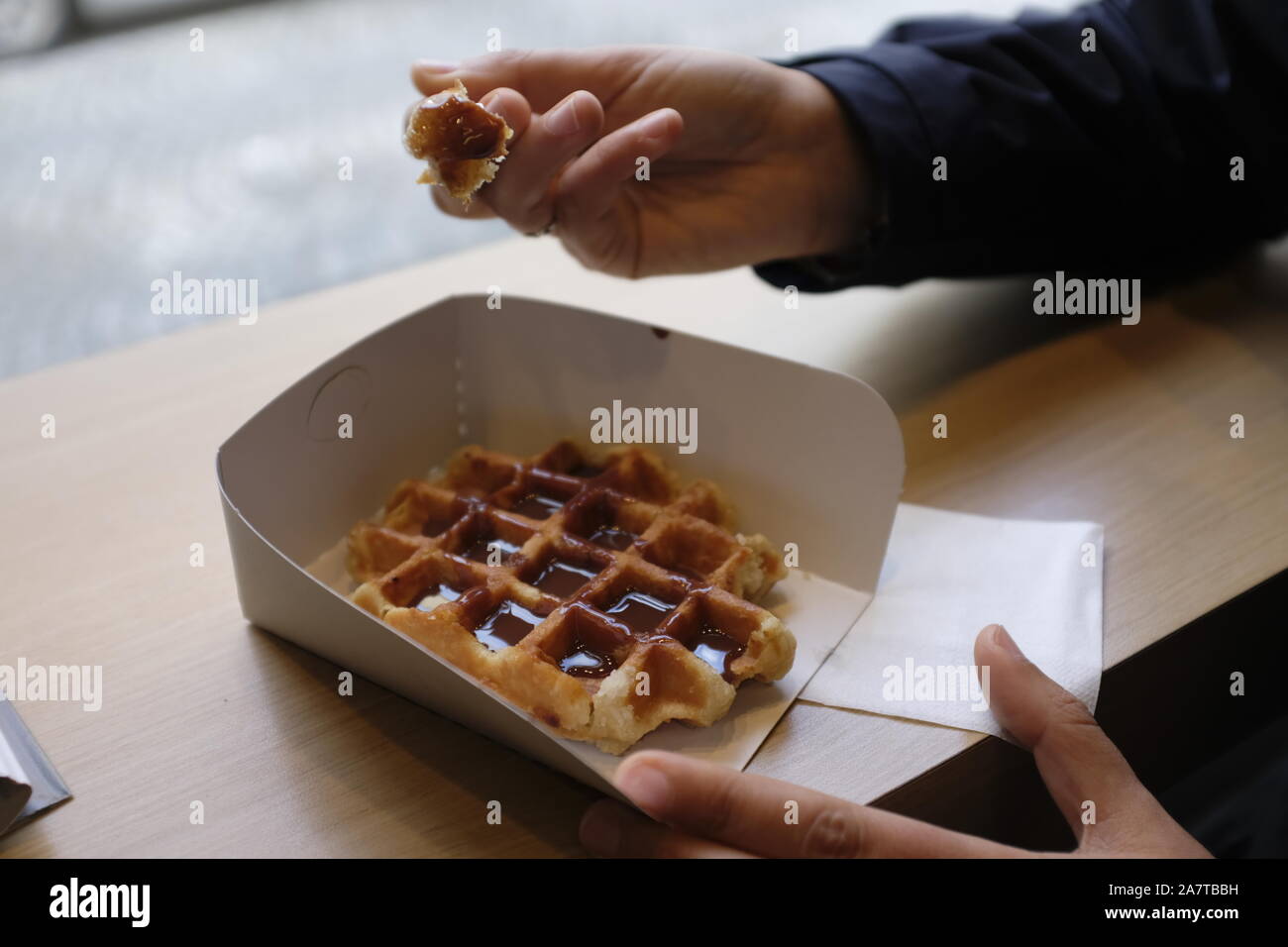 Das Essen einer Schokolade Waffel auf Papier in Belgien Stockfoto