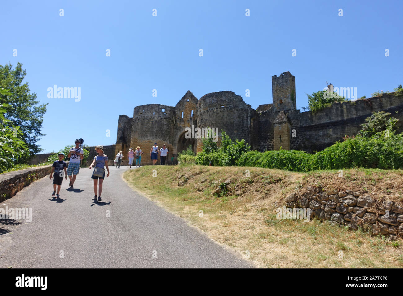 Domme, Frankreich vom 15. Juli 2019: Touristen auf dem Weg zum und vom Turm und Tor Porte des Tours mittelalterlichen Eingang der Stadt Domme in Frankreich Stockfoto