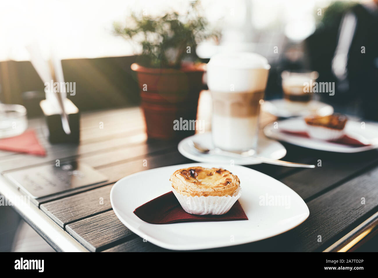 Portugiesische Backwaren Pastel de auf Holztisch mit heißem Kaffee berverage Nata Stockfoto