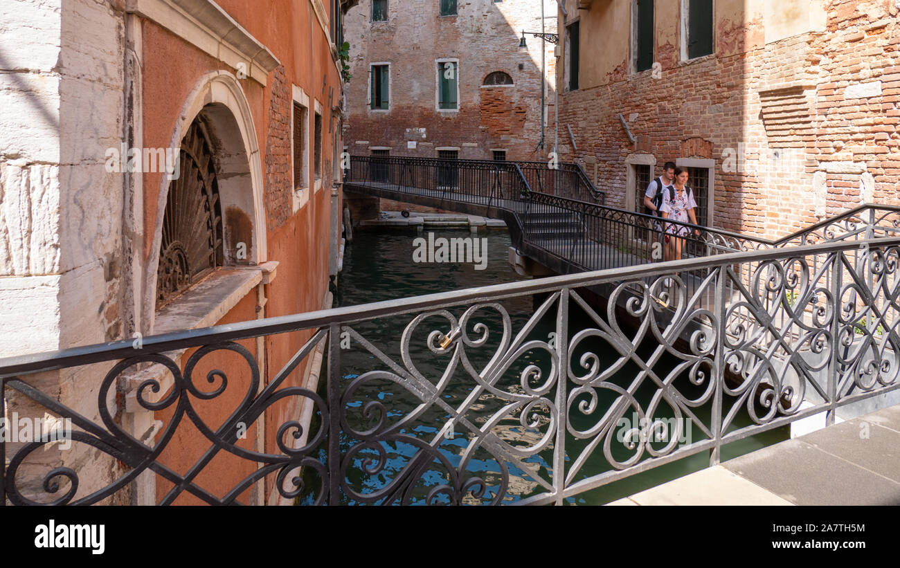 Venedig Italien 08 14 2019 junges Paar zu Fuß auf einer metallenen Brücke über einen Kanal in Venedig Italien Stockfoto