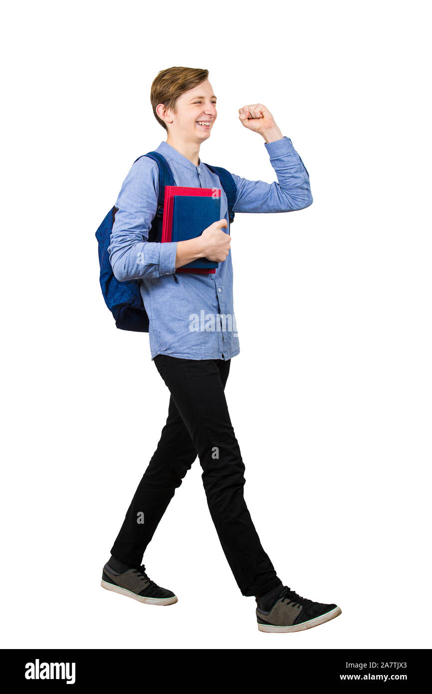 Volle Länge des zuversichtlich Student boy feiern die Prüfung bestehen wie zum Heben einer Hand zwei Bücher und seinen Rucksack auf dem Weg nach Hause. Jubeln Stockfoto