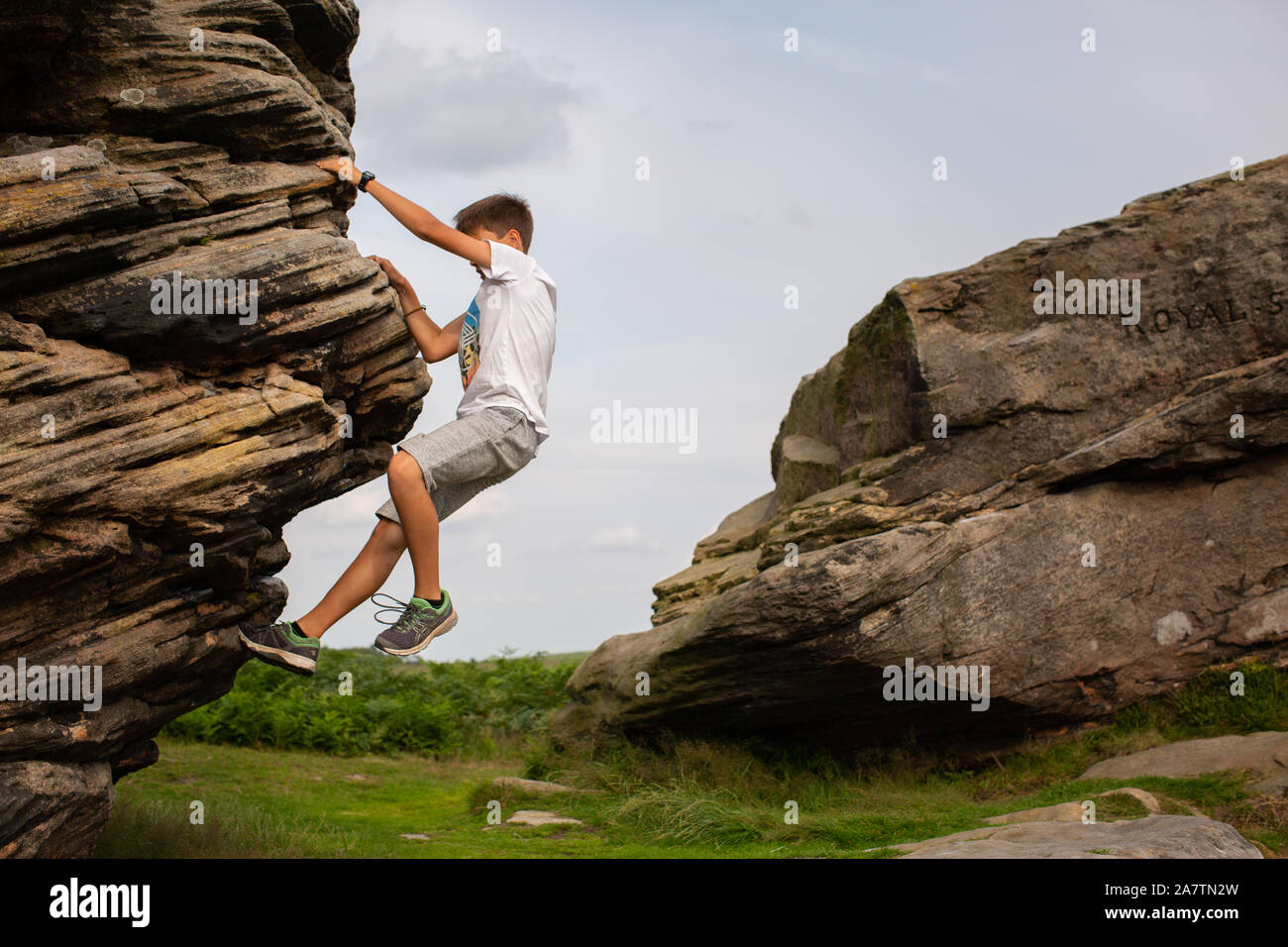 Ein 11 Jahre alter Junge klettern auf den drei Schiffen im Peak District, England, Großbritannien Stockfoto