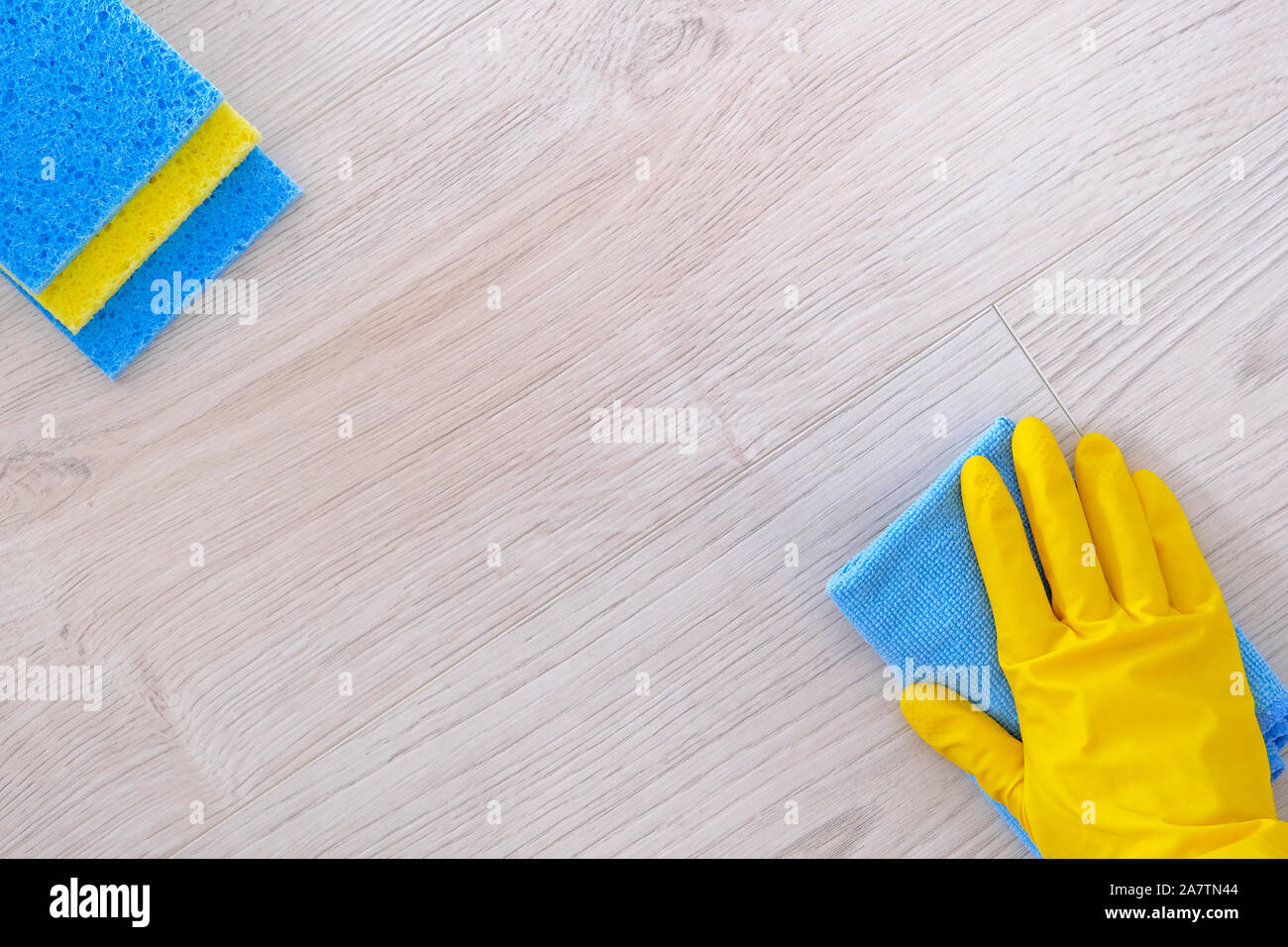 Ansicht von oben. Reinigung Konzept im Büro, zu Hause. Hand in gelb Gummi Schutzhandschuh mit Mikrofasertuch abwischen. Nahaufnahme Stockfoto