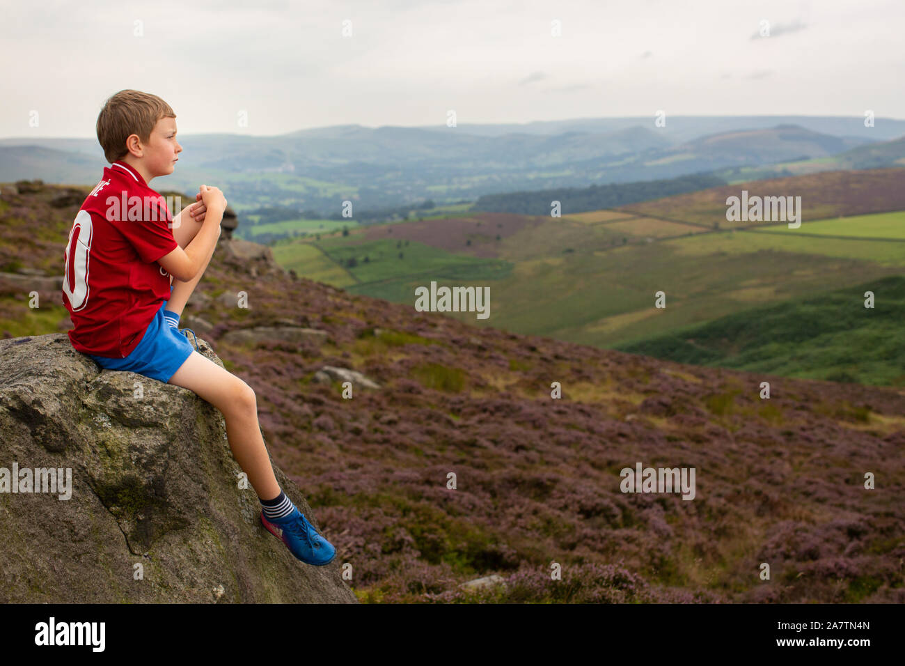 Ein Junge mit Blick über die Ansicht des Peak District. Stockfoto