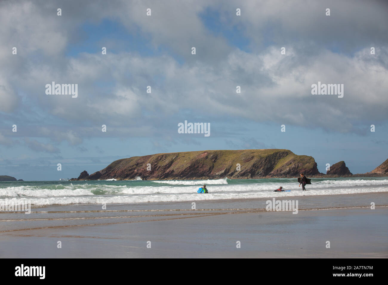 Drei Personen ihren Surfbrettern in die das Meer, Pembrokeshire, Wales, UK. Stockfoto