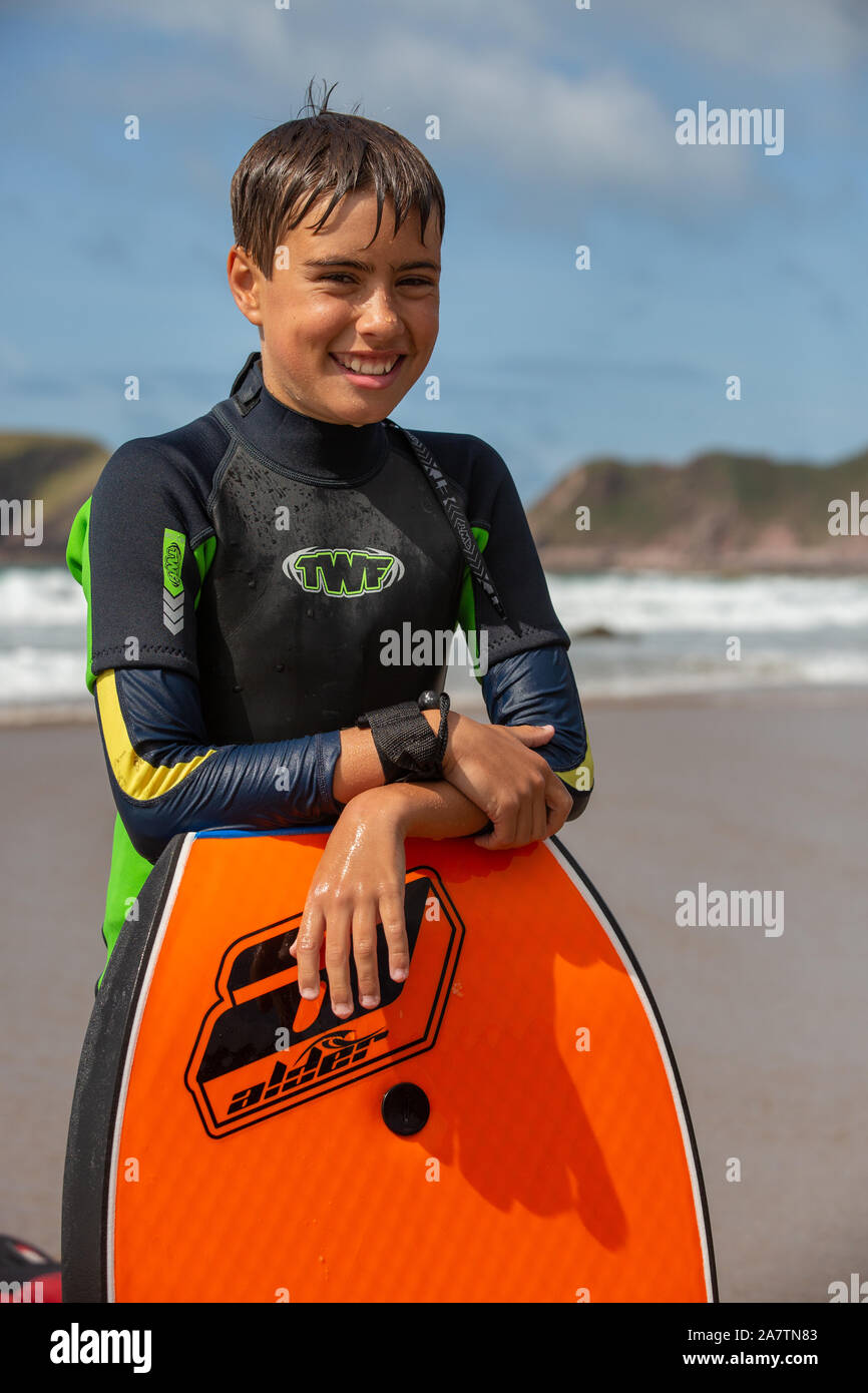 Ein gutes Porträt eines 11-jährigen Jungen mit einem Body Board auf einem Strand in Pembrokeshire, Wales Stockfoto