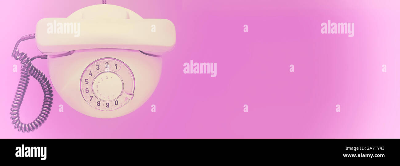 Weiß altes Telefon mit Drehschalter auf lila Hintergrund. Verblasste Wirkung. Flach. Ansicht von oben. Banner. Für text Stockfoto