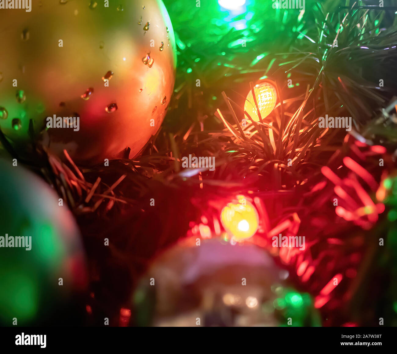 Nasse Weihnachtsverzierungen und Lichter auf einem im Baum Stockfoto