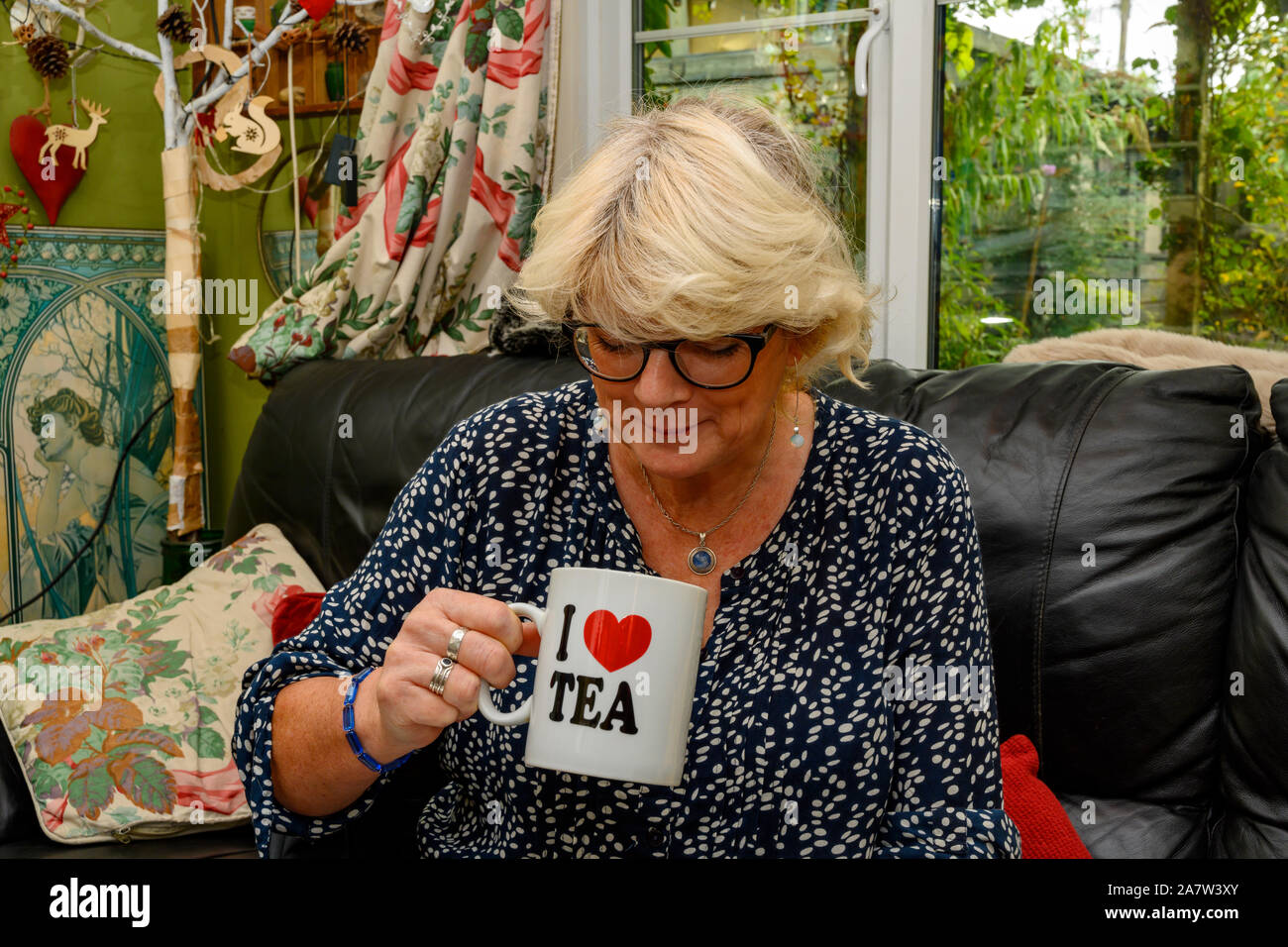Frau mittleren Alters genießen eine Tasse Kaffee zu Hause Stockfoto