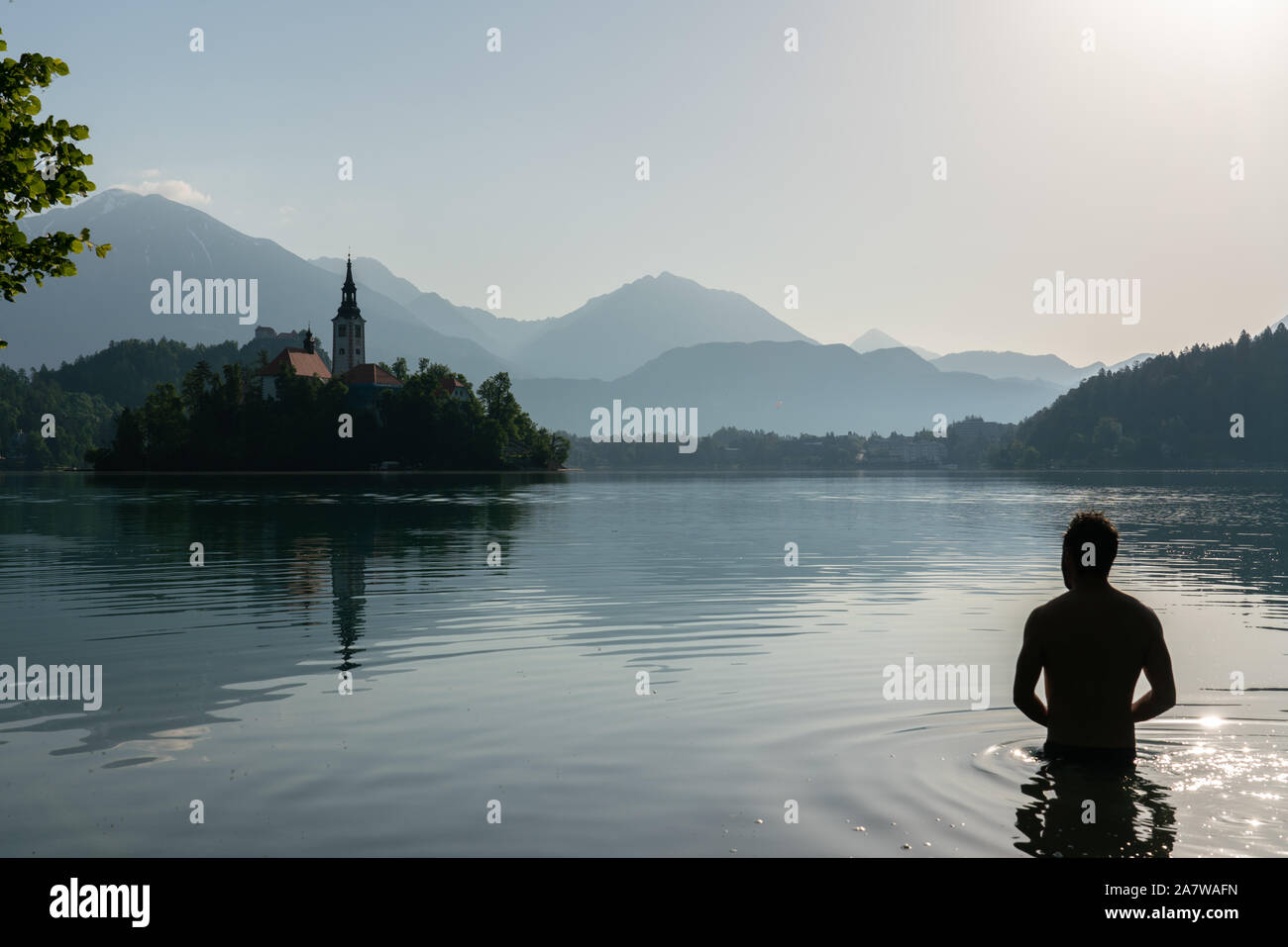 Silhouette eines Europäischen mann Baden in der See von Bled beim Üben der Wim Hof ​​meditation Methode Stockfoto