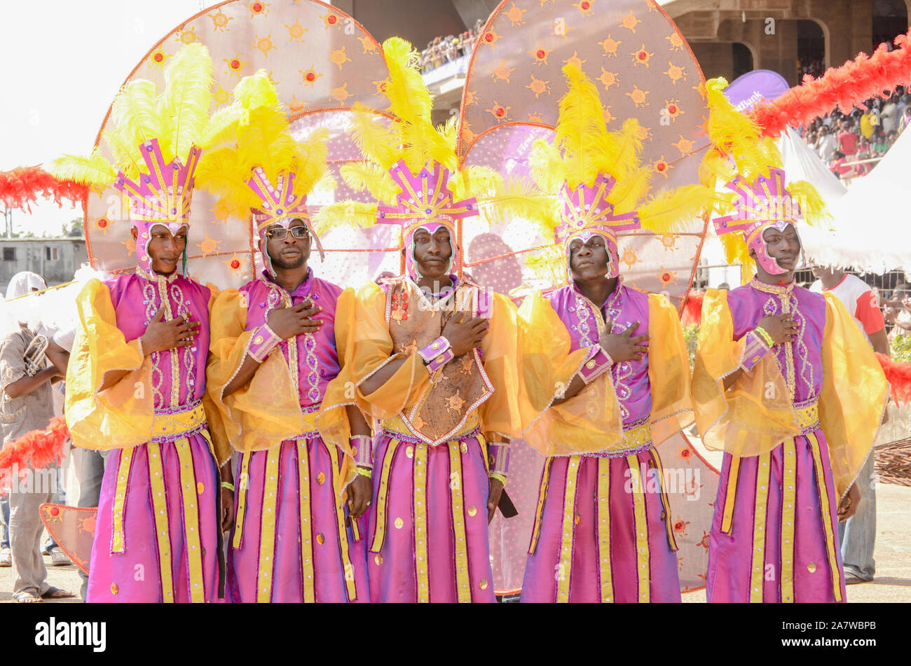 Junge Männer in ihrem bunten Kostüm rezitieren die nigerianische Nationalhymne beim Karneval in Lagos. Stockfoto