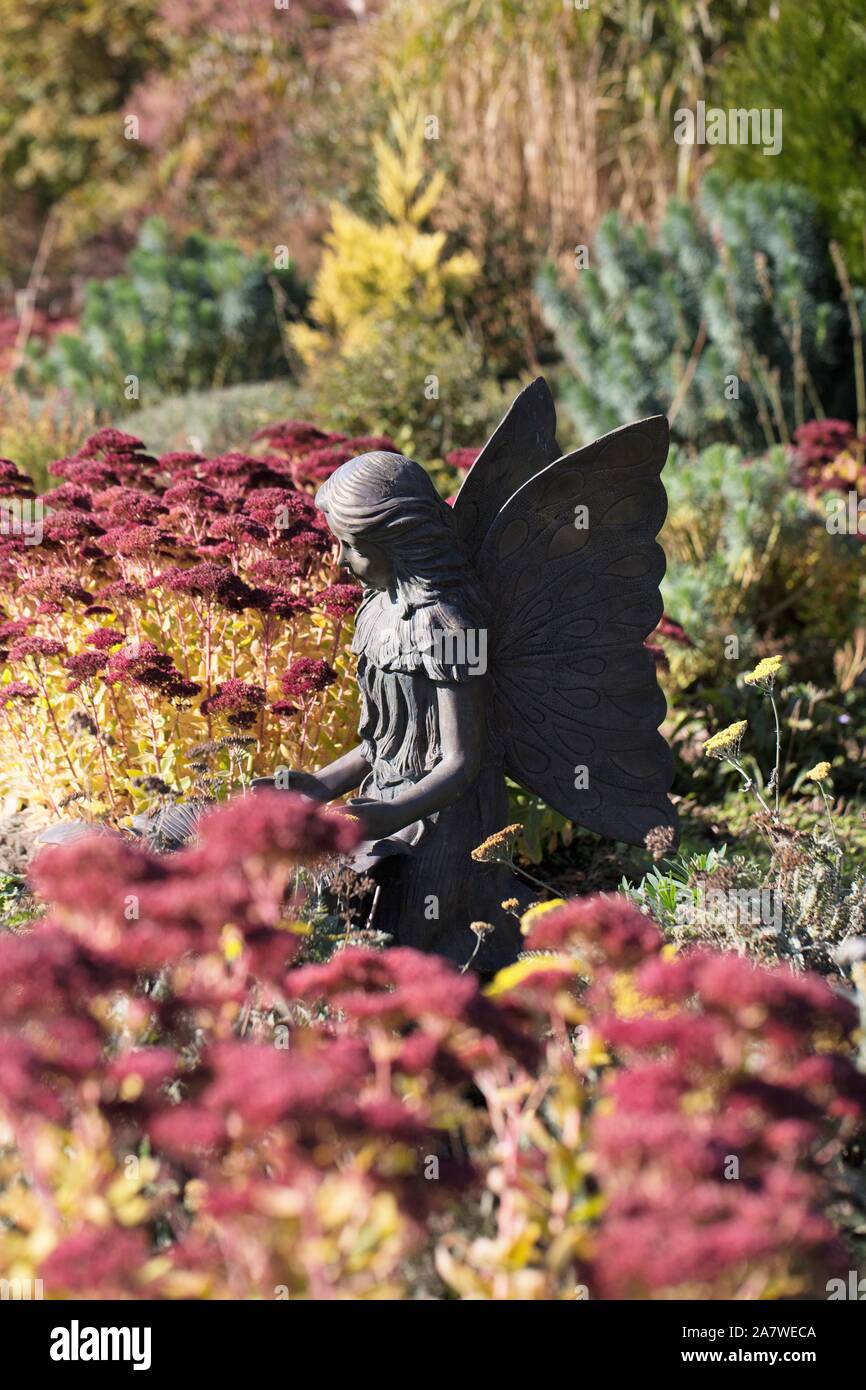 Eine Statue von einem Schmetterling Mädchen in einem Garten von mauerpfeffer sedum album im Herbst, an der Oregon Garten in Silverton, Oregon, USA. Stockfoto