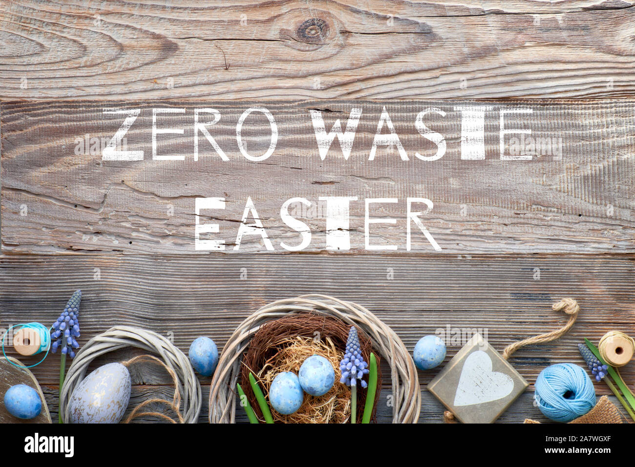 Ostern Hintergrund mit blauen Hyazinthe Blumen, bunte Eier, Holz- Herz und Dekorationen auf rustikalem Holz mit Text "Null Abfall Ostern". Umweltfreundliche wa Stockfoto