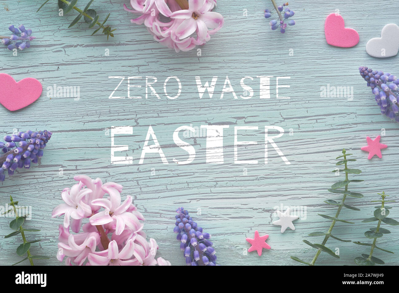 Pearl und Traubenhyazinthen Blumen und natürlichen Eukalyptus Blätter auf Licht strukturierten Hintergrund. Text "Null Abfall Ostern" auf grüne Minze knisterte Holz. Eco Stockfoto