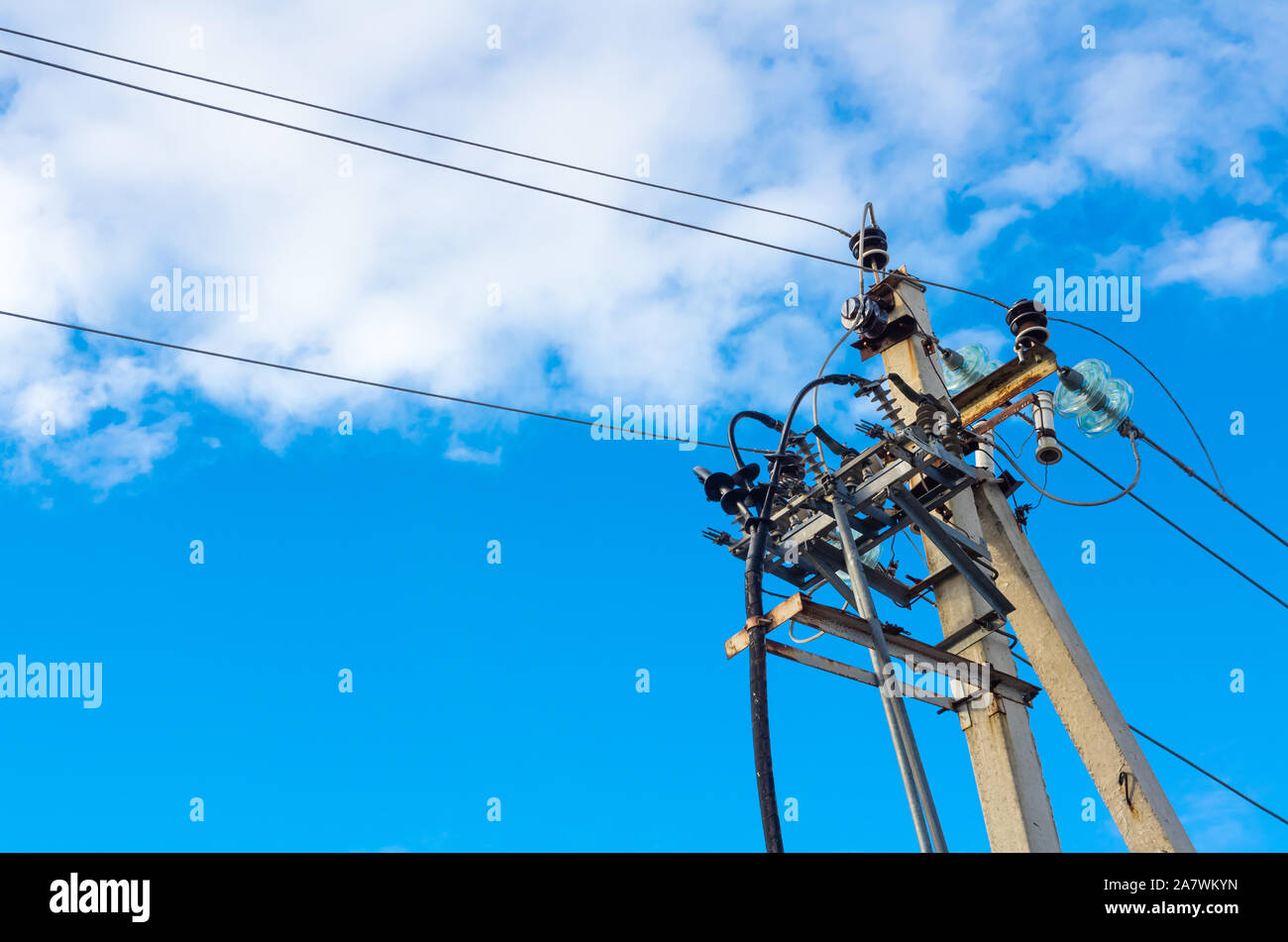 Elektrische Post mit Power line Kabel gegen den blauen Himmel Stockfoto